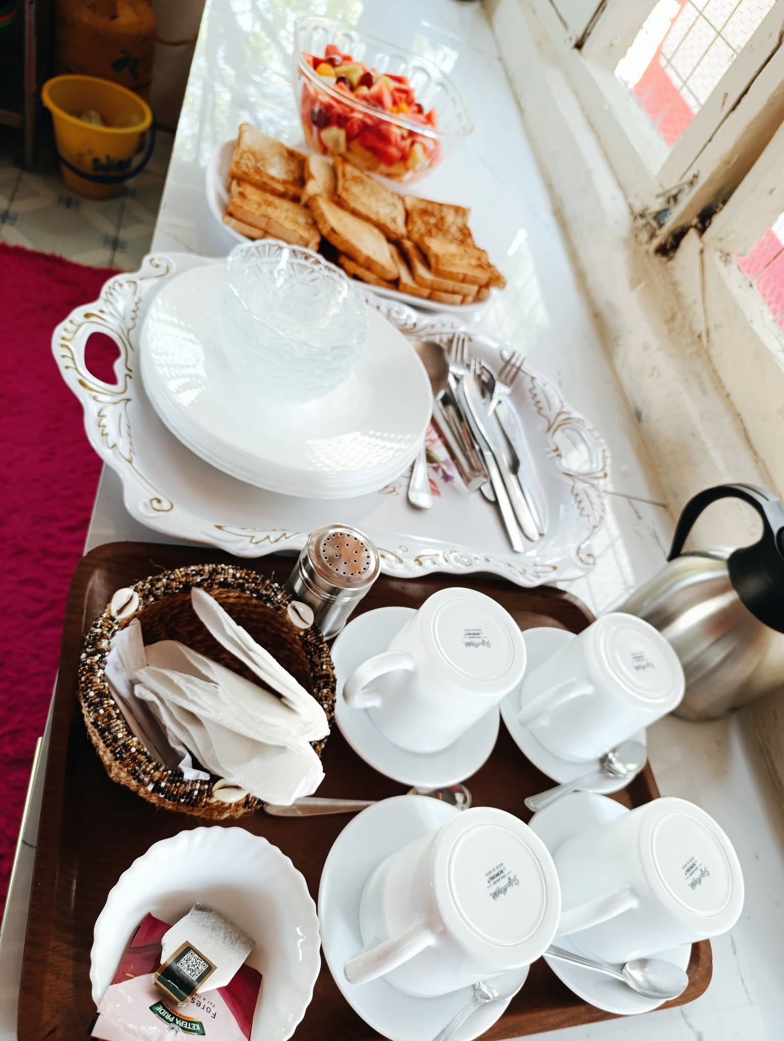 Breakfast laid out on the riverside deck — fresh fruit, toast, coffee and tea