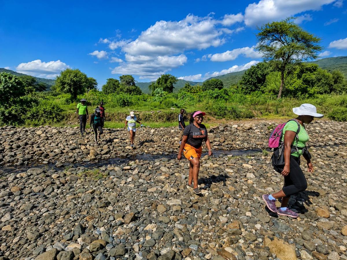 Guests crossing the riverbed near a fishing spot on the Ewaso Ng'iro River